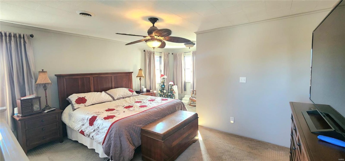 Carpeted bedroom featuring ceiling fan