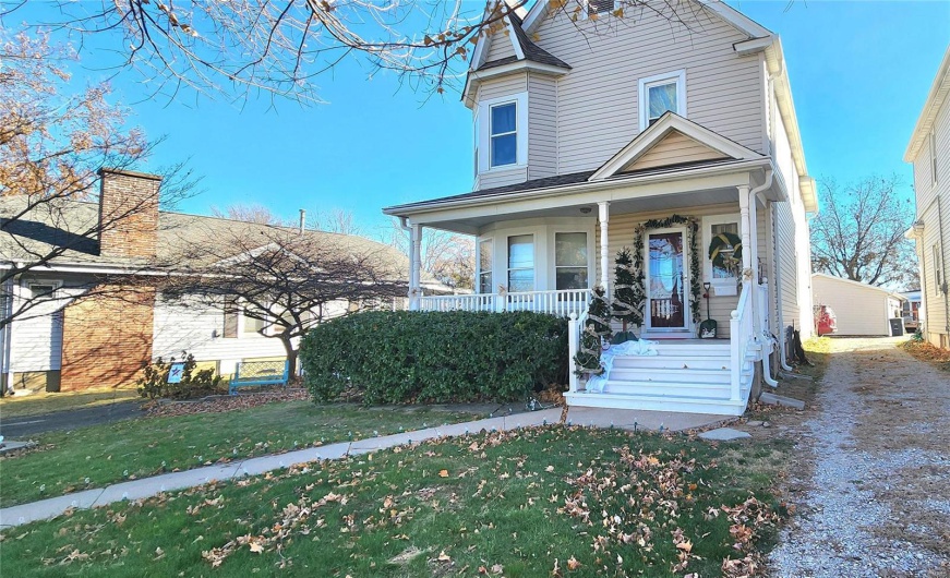 View of front facade featuring a front lawn and covered porch