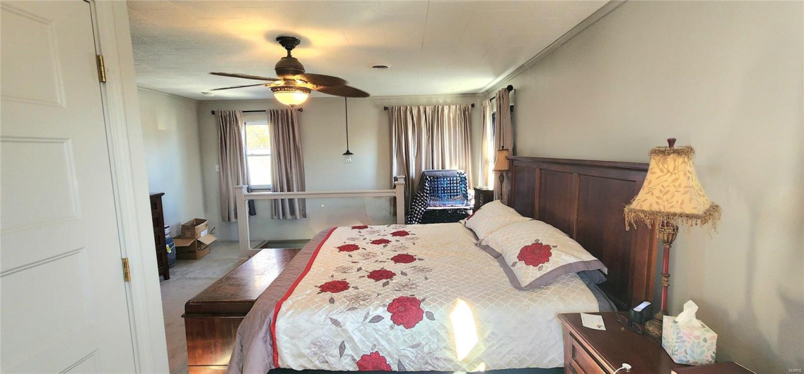 Bedroom with ceiling fan and crown molding