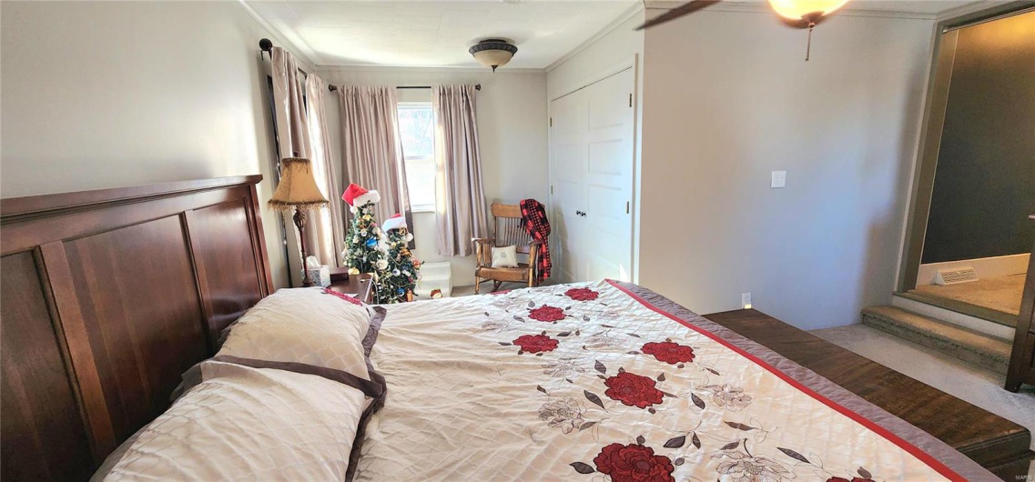 Bedroom featuring ceiling fan and ornamental molding