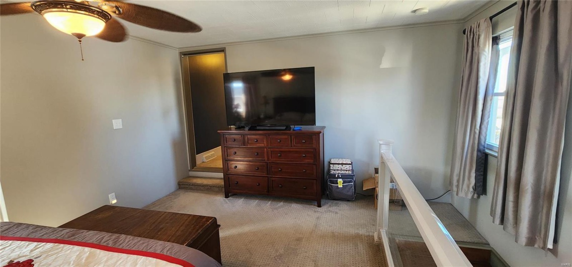 Bedroom featuring light carpet and ceiling fan
