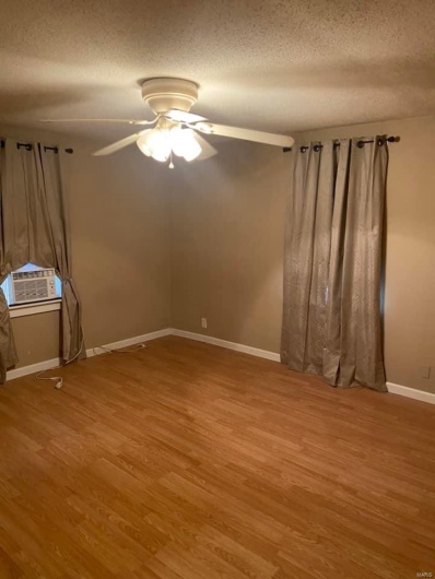 Unfurnished room featuring wood-type flooring, a textured ceiling, and ceiling fan