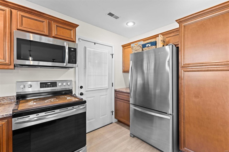 Kitchen featuring stainless steel appliances, stone counters, and light hardwood / wood-style flooring
