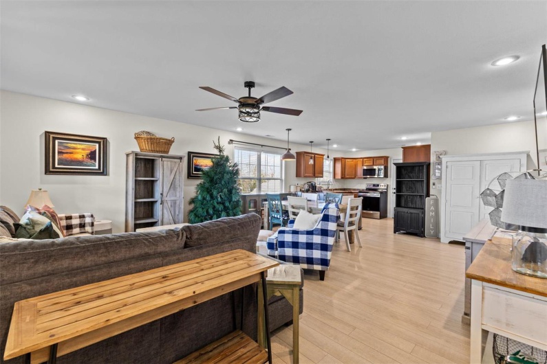Living room with ceiling fan and light hardwood / wood-style floors