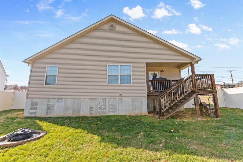Rear view of house with a lawn and a deck