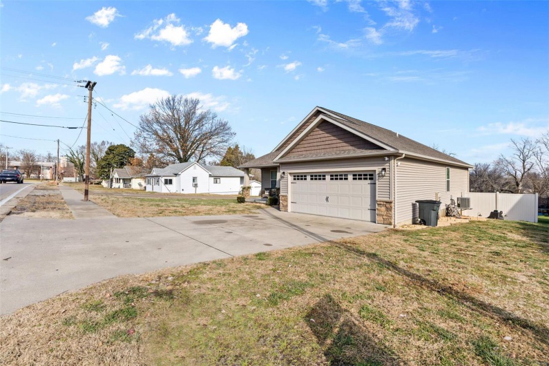 View of property exterior featuring a yard and a garage