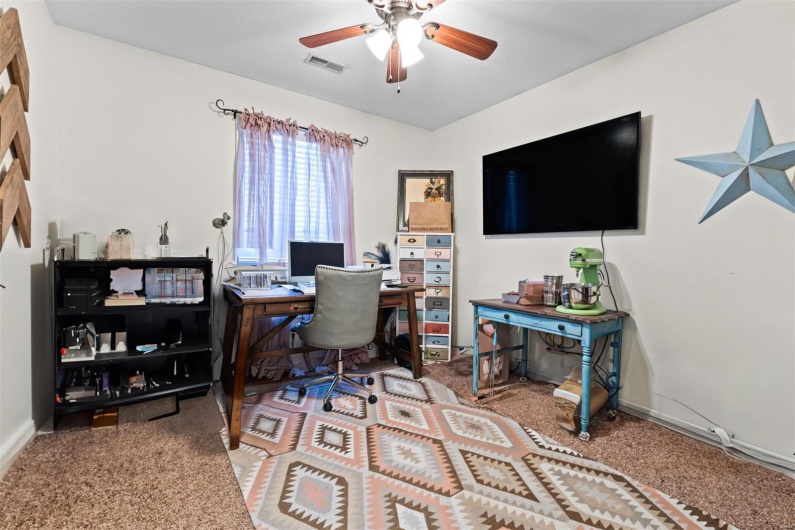 Carpeted office space with ceiling fan