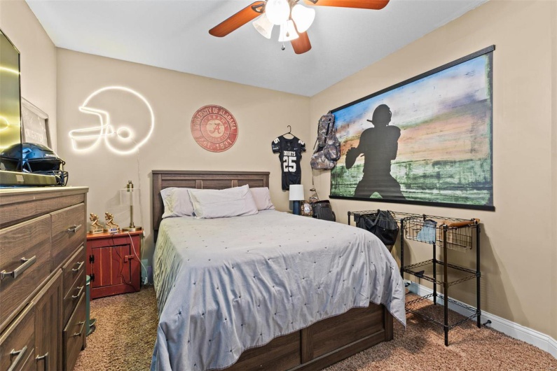 Carpeted bedroom featuring ceiling fan