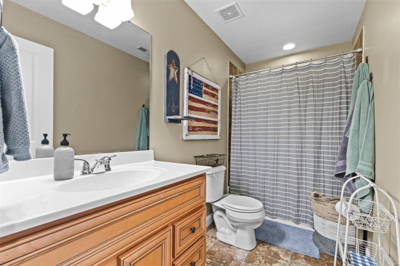 Bathroom with a shower with shower curtain, vanity, and toilet