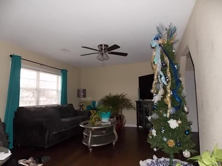 Living room featuring ceiling fan and dark hardwood / wood-style flooring