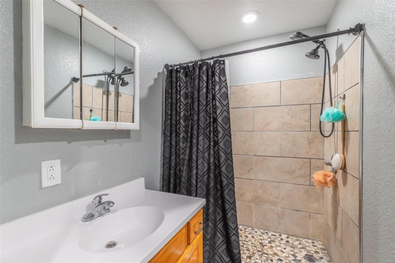 Bathroom featuring vanity, a textured ceiling, and walk in shower