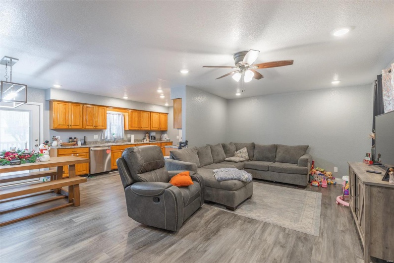 Living room with ceiling fan, light hardwood / wood-style floors, and a textured ceiling