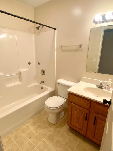 Full bathroom with vanity,  shower combination, and toilet