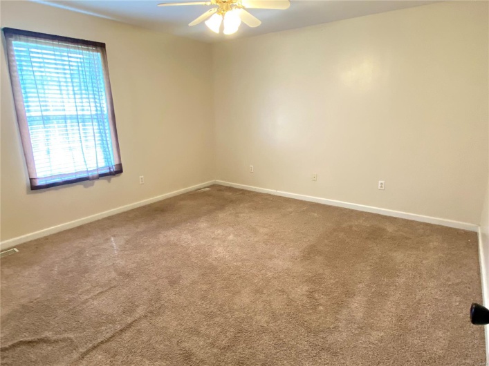 Carpeted empty room with baseboards and ceiling fan