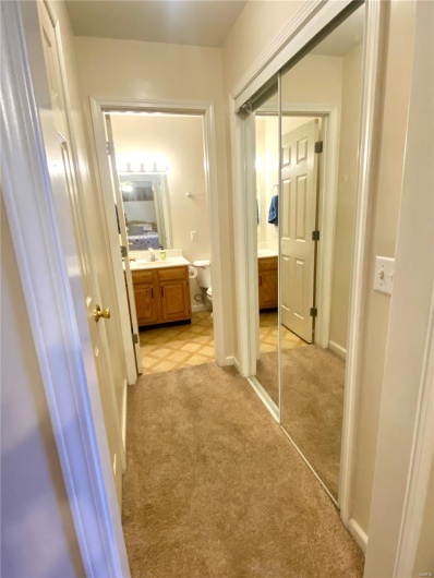 Corridor featuring sink and light colored carpet