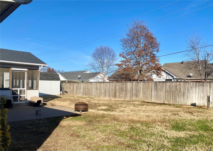 View of yard with a patio area, a sunroom, and an outdoor fire pit