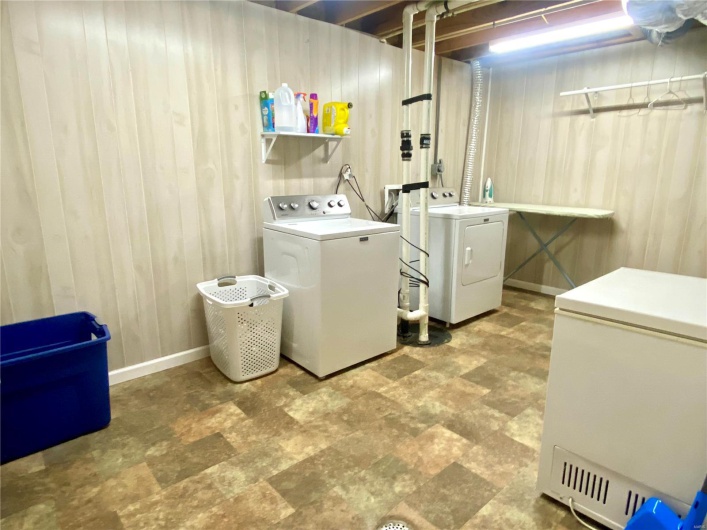 Laundry room with wood walls and washer and clothes dryer