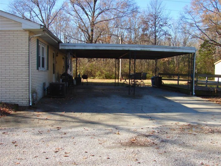 View of parking / parking lot featuring a carport