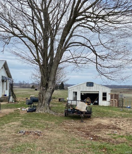 View of yard with a rural view and an outdoor structure