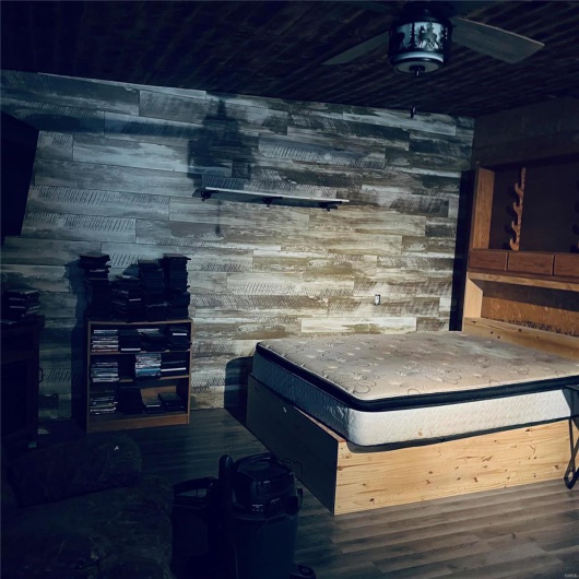 Bedroom featuring wood walls and dark hardwood / wood-style floors