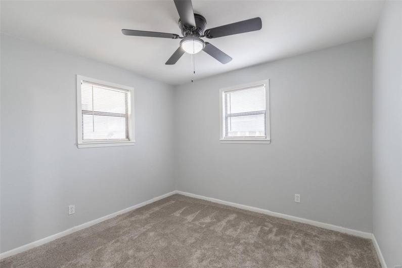 Carpeted empty room featuring ceiling fan
