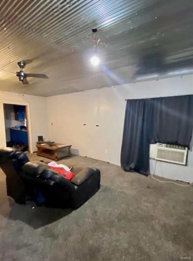Living room with a wall unit AC and ceiling fan