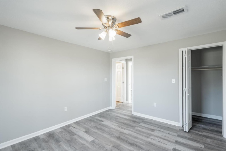 Unfurnished bedroom featuring ceiling fan, light hardwood / wood-style floors, and a closet