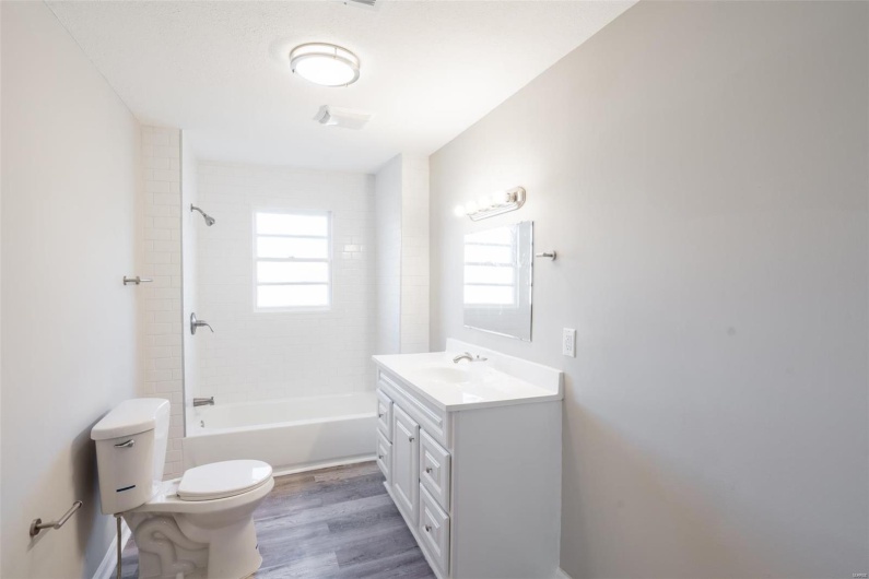 Full bathroom featuring wood-type flooring, vanity, toilet, and tiled shower / bath