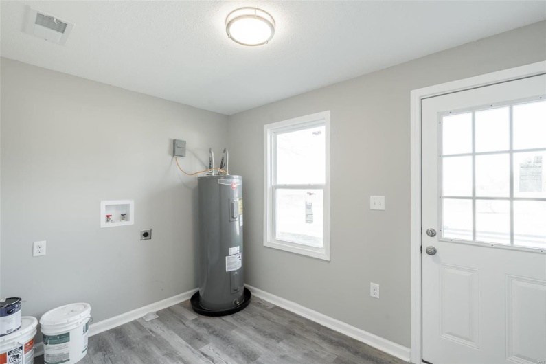 Washroom with hookup for an electric dryer, washer hookup, electric water heater, and plenty of natural light