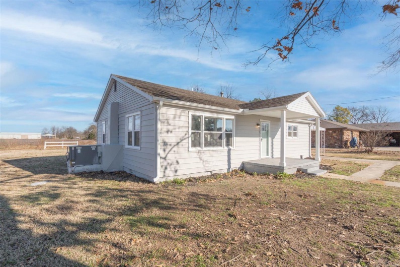 Bungalow-style house with a porch, a front lawn, and central air condition unit