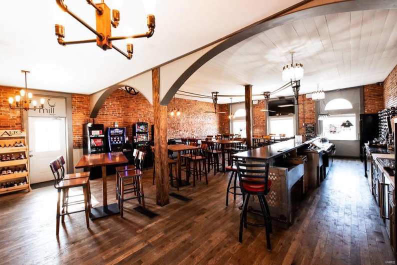 Dining area featuring brick wall, dark hardwood / wood-style floors, and a notable chandelier
