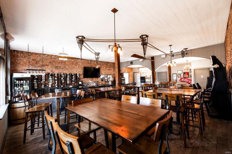 Dining area featuring hardwood / wood-style flooring, a notable chandelier, and brick wall