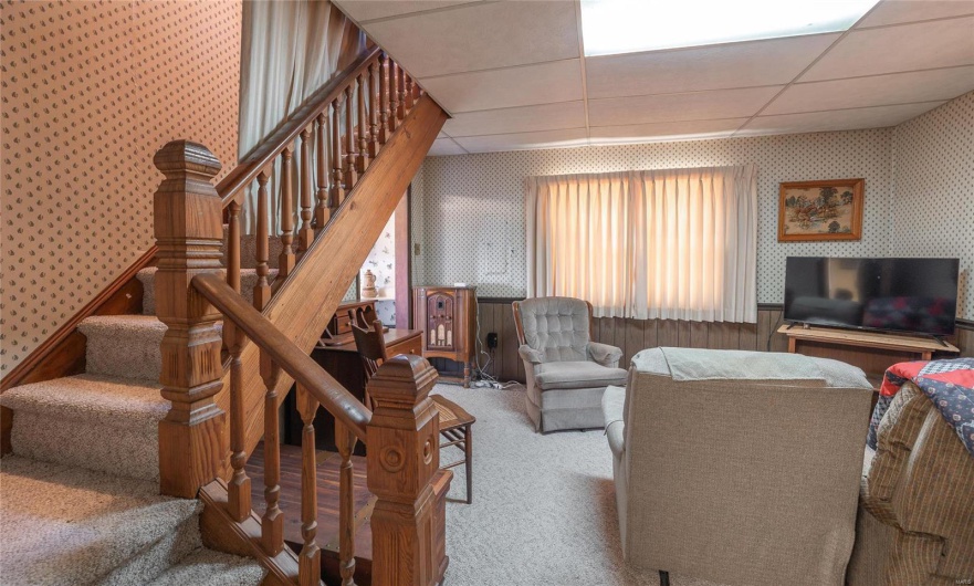 Carpeted living room featuring a paneled ceiling