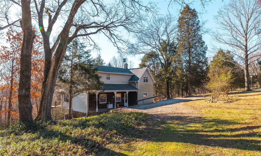 View of front of property featuring covered porch and a front lawn