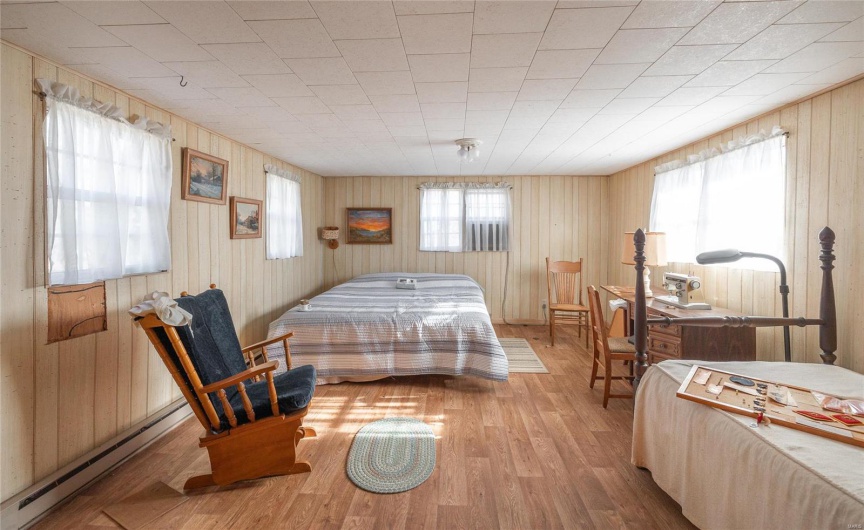 Bedroom with light hardwood / wood-style floors and a baseboard radiator
