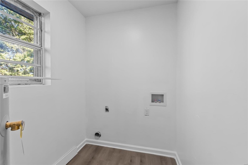 Clothes washing area with hookup for a washing machine, dark hardwood / wood-style floors, and hookup for an electric dryer