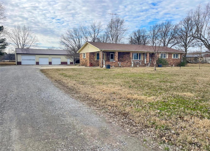 Ranch-style house with an outbuilding, a garage, and a front lawn