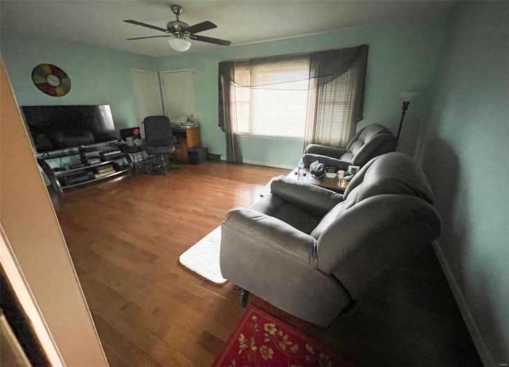 Living room with ceiling fan and wood-type flooring