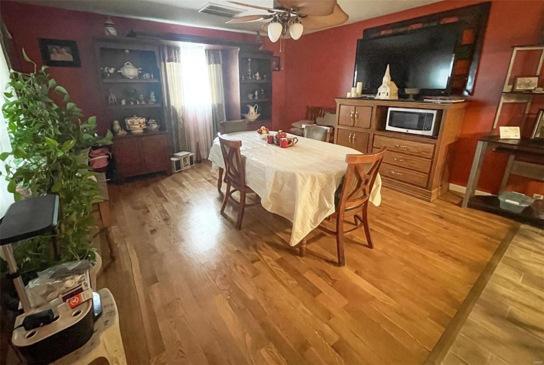 Dining space with ceiling fan and wood-type flooring