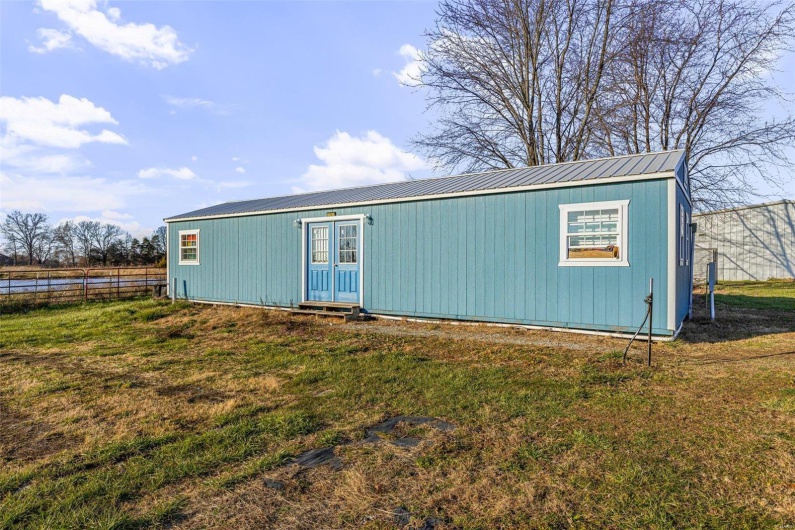 View of outdoor structure featuring a yard