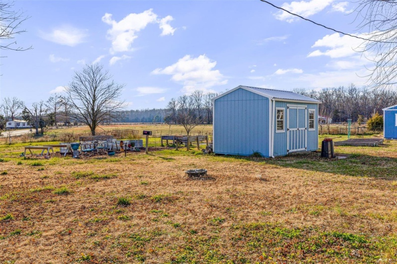 View of outbuilding featuring a lawn and a rural view