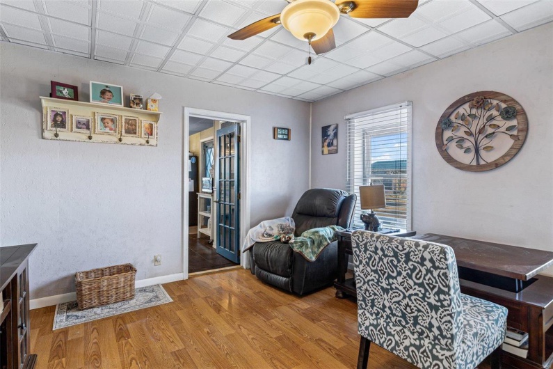 Home office with hardwood / wood-style floors and ceiling fan