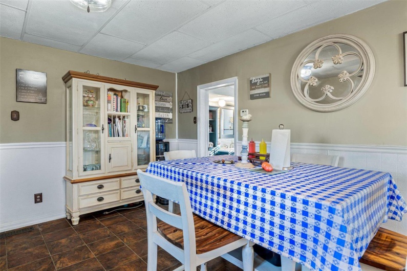 Tiled dining area featuring a drop ceiling