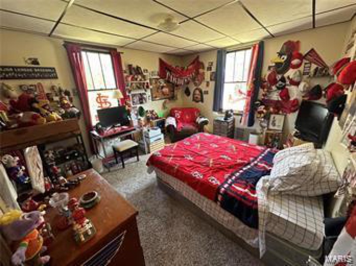Bedroom with a drop ceiling and multiple windows