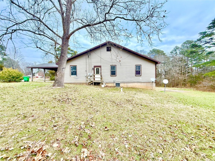 Back of house with a yard