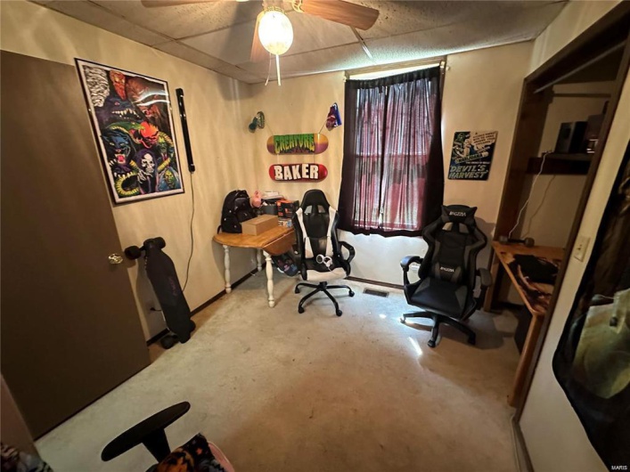 Office space with a paneled ceiling and ceiling fan