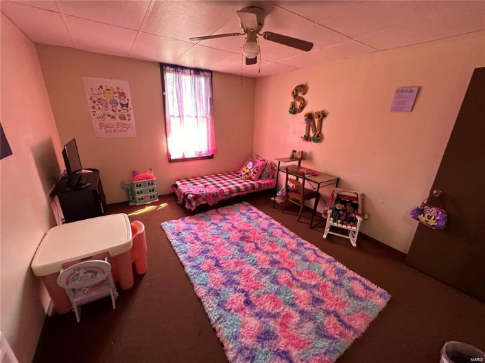Bedroom featuring a drop ceiling and ceiling fan