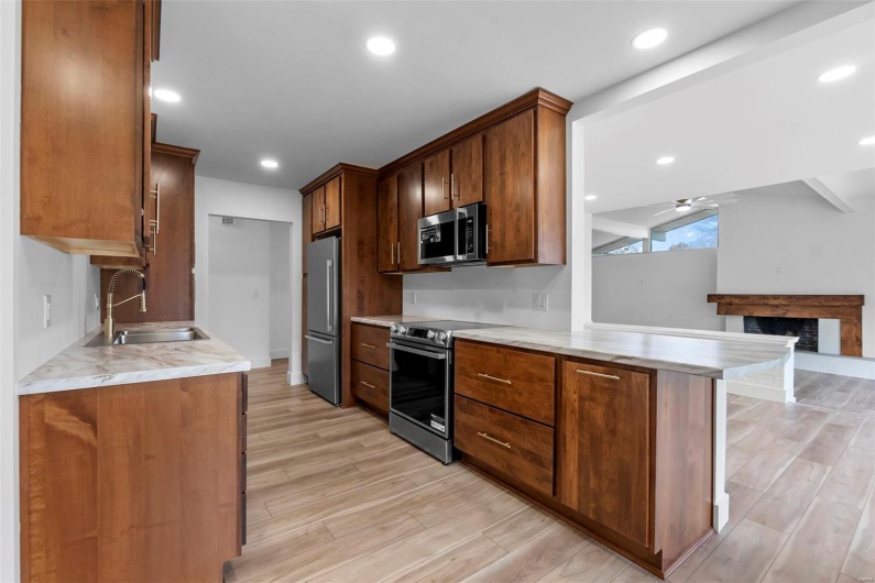 Kitchen with light hardwood/wood-style flooring, appliances with stainless steel finishes