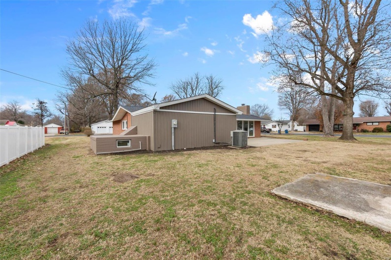 Back of house with a lawn and central air condition unit