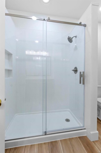 Bathroom with toilet and a tile shower with door